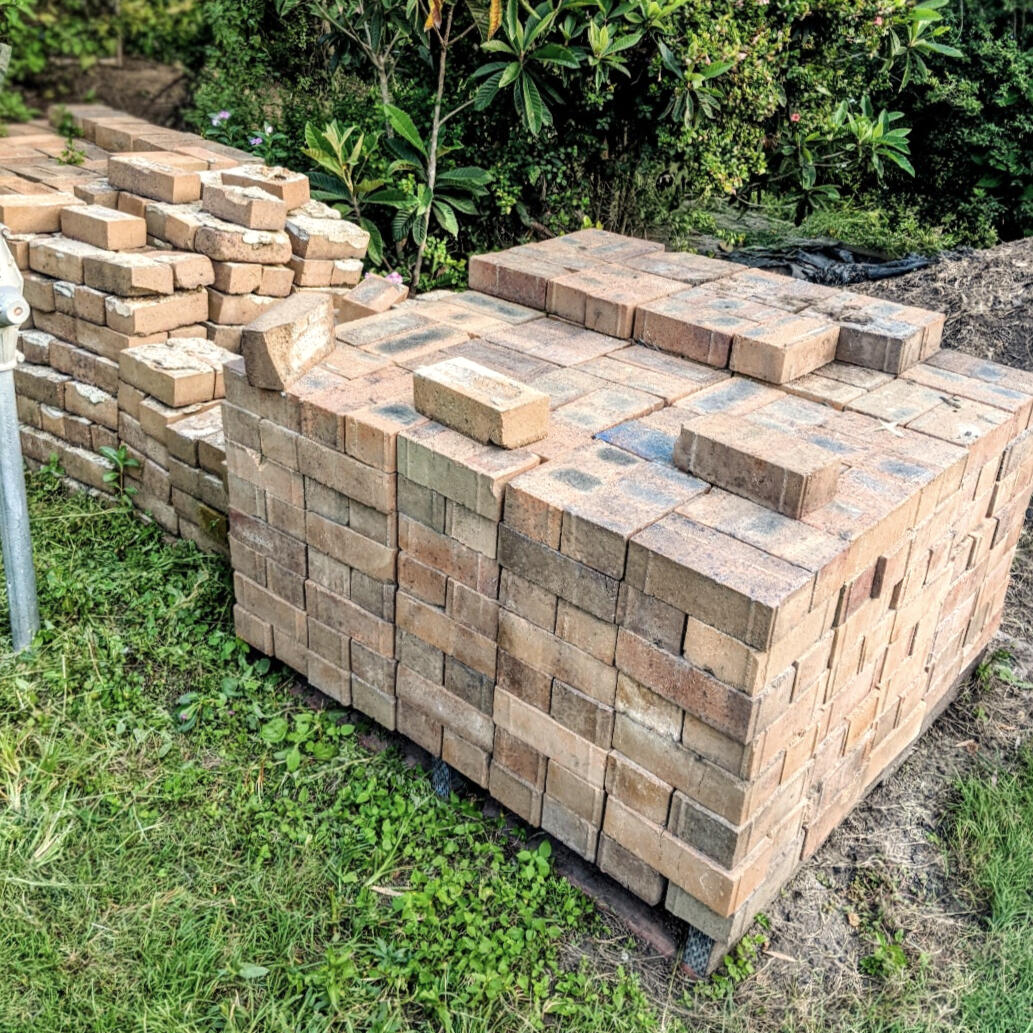 Recycled Face Bricks Awaiting Reuse Studio Violett Oxley Farmhouse salvaged face bricks stacked on site showcasing textured earth tones and tactile material reuse